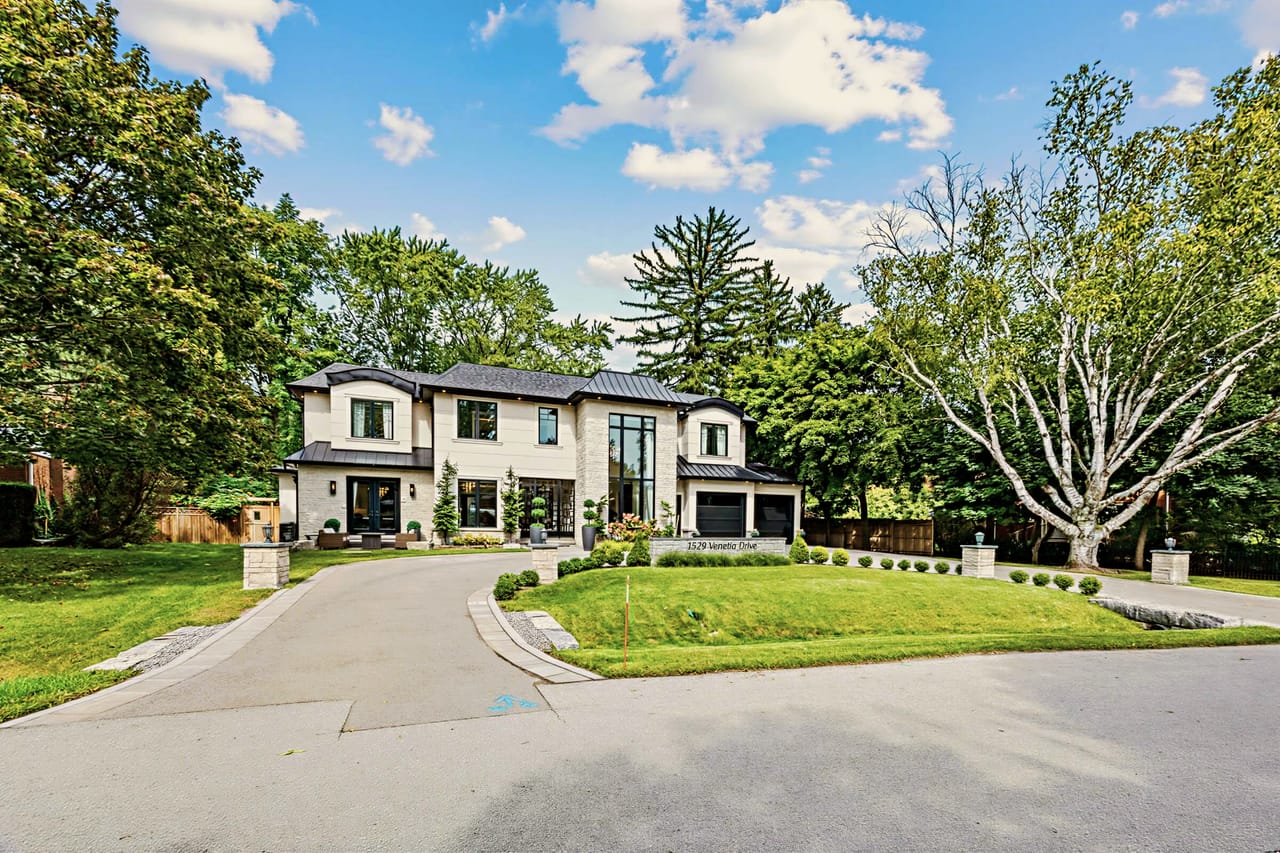 Full front elevation in daylight, the circular drive sweeping past a mature silver maple
