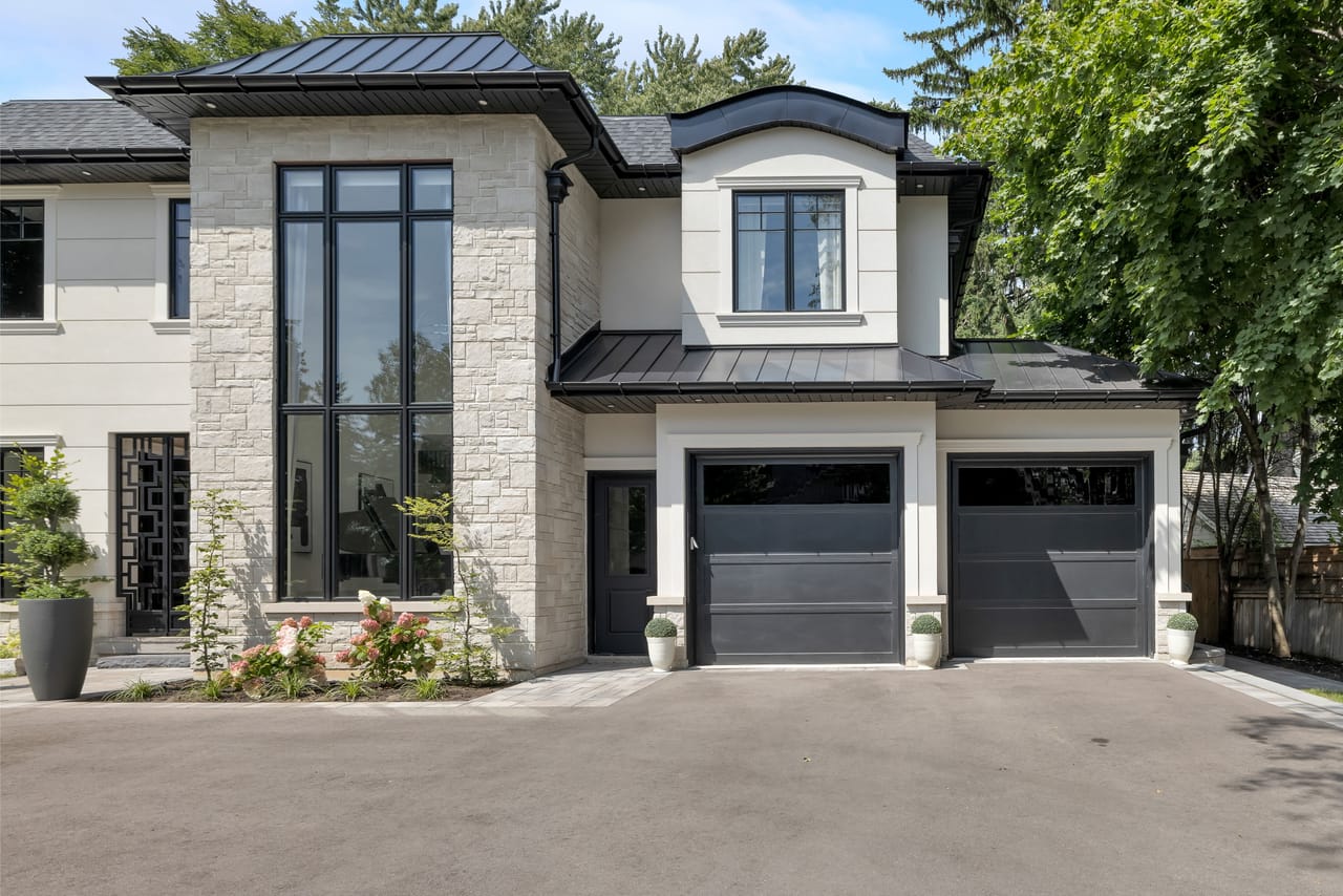 Daytime view of the garage wing, paired bays beside a double-height stone window bay