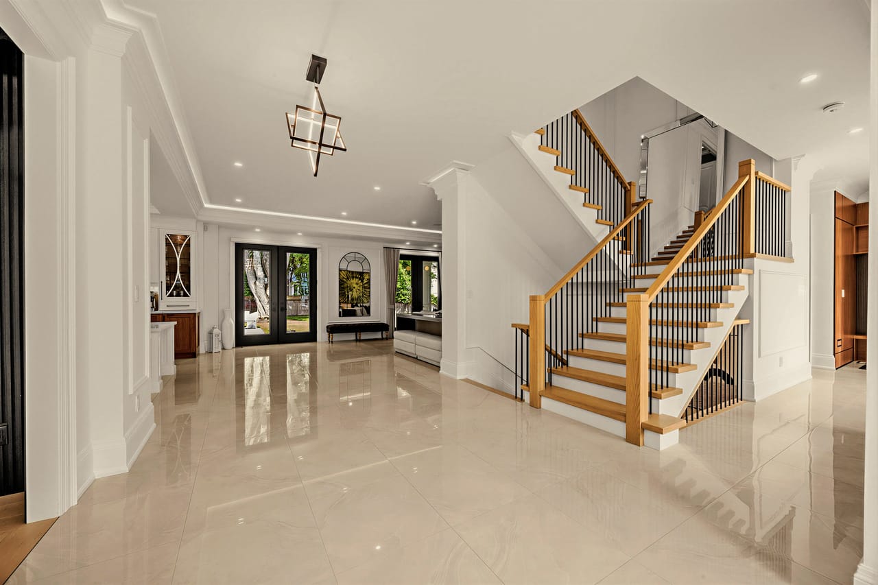 Wide view of the foyer, staircase and gallery hall beneath a sculptural lantern