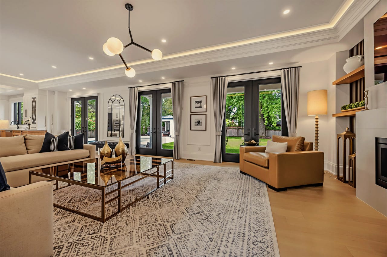 Living room with linear fireplace and French doors opening to the rear grounds