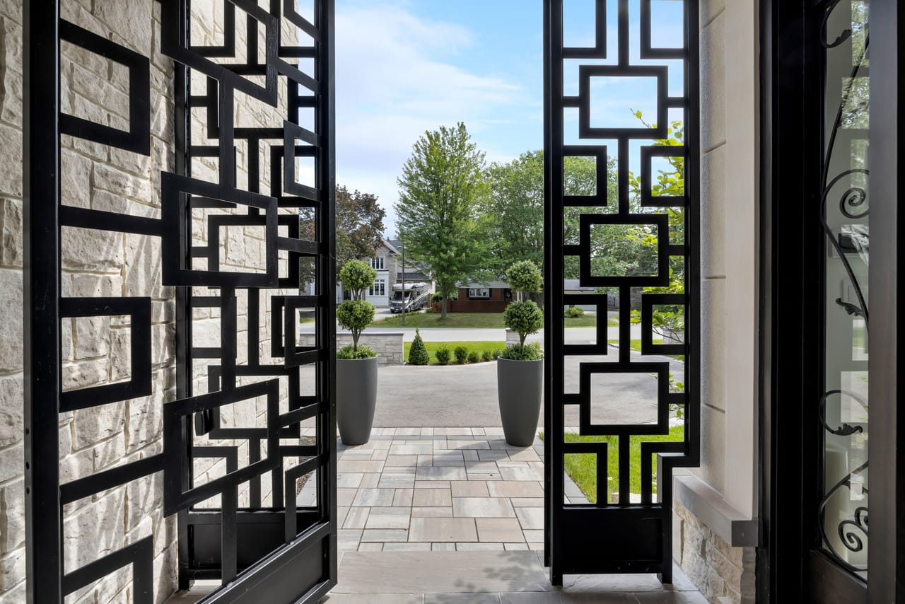 View from the front entry through the open metal door to the tree-lined street