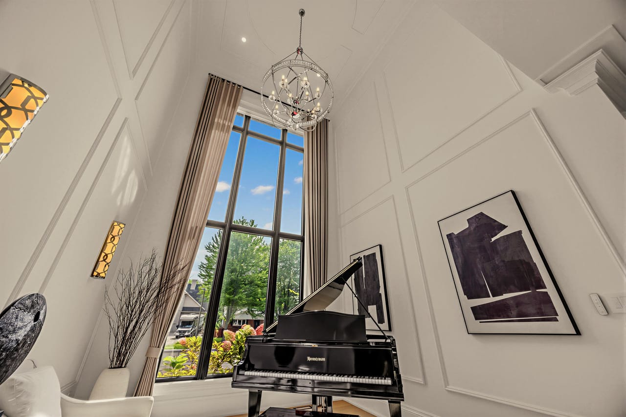 Two-storey music room, a wall of glass rising the full height beside the grand piano