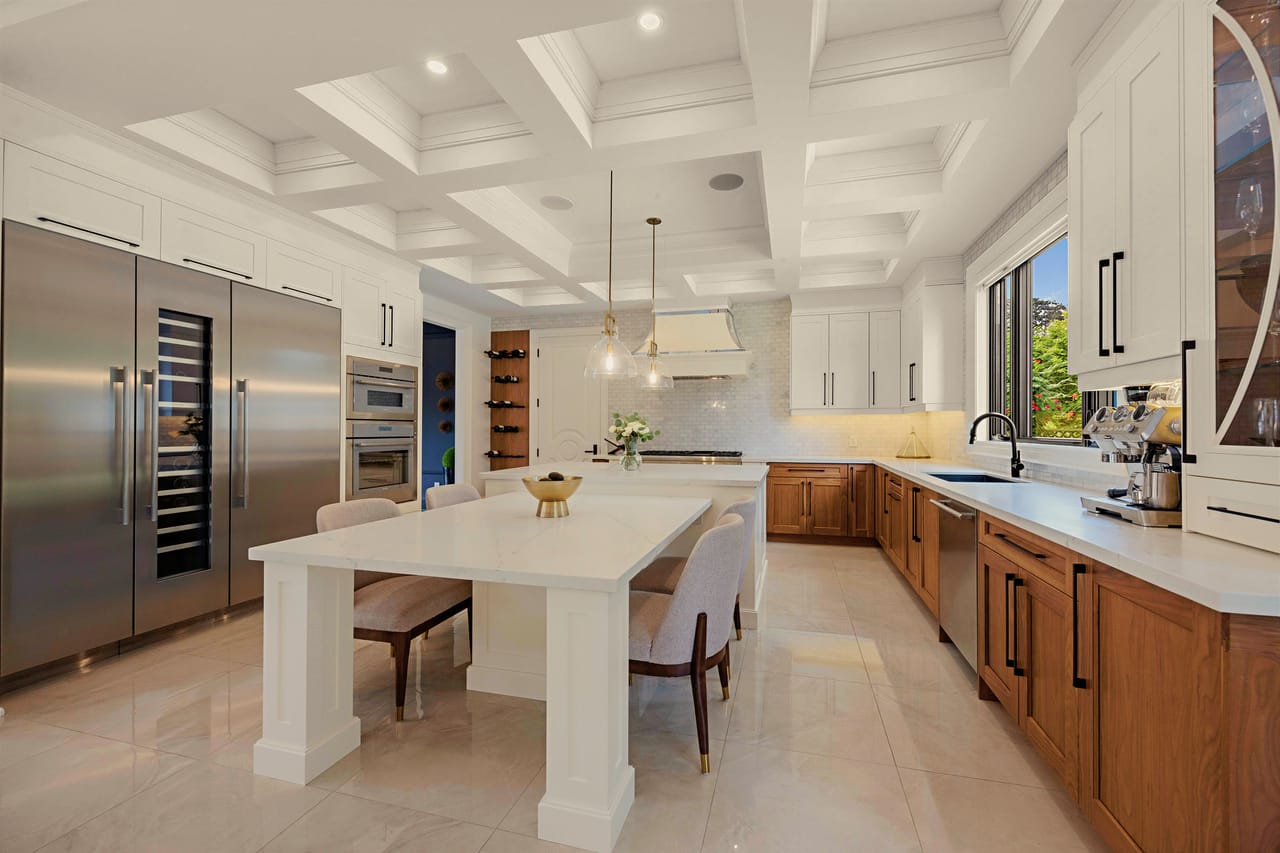 The kitchen in full, white oak cabinetry running to the integrated column refrigeration