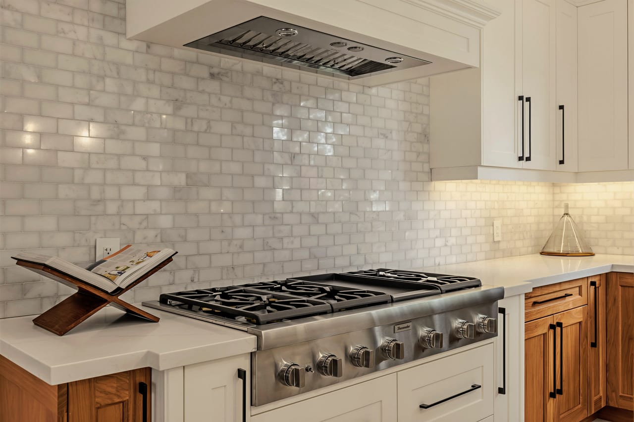 Detail of the professional gas range and glazed subway backsplash