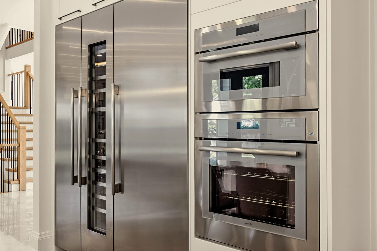 Thermador wall ovens beside the refrigeration and wine columns off the kitchen