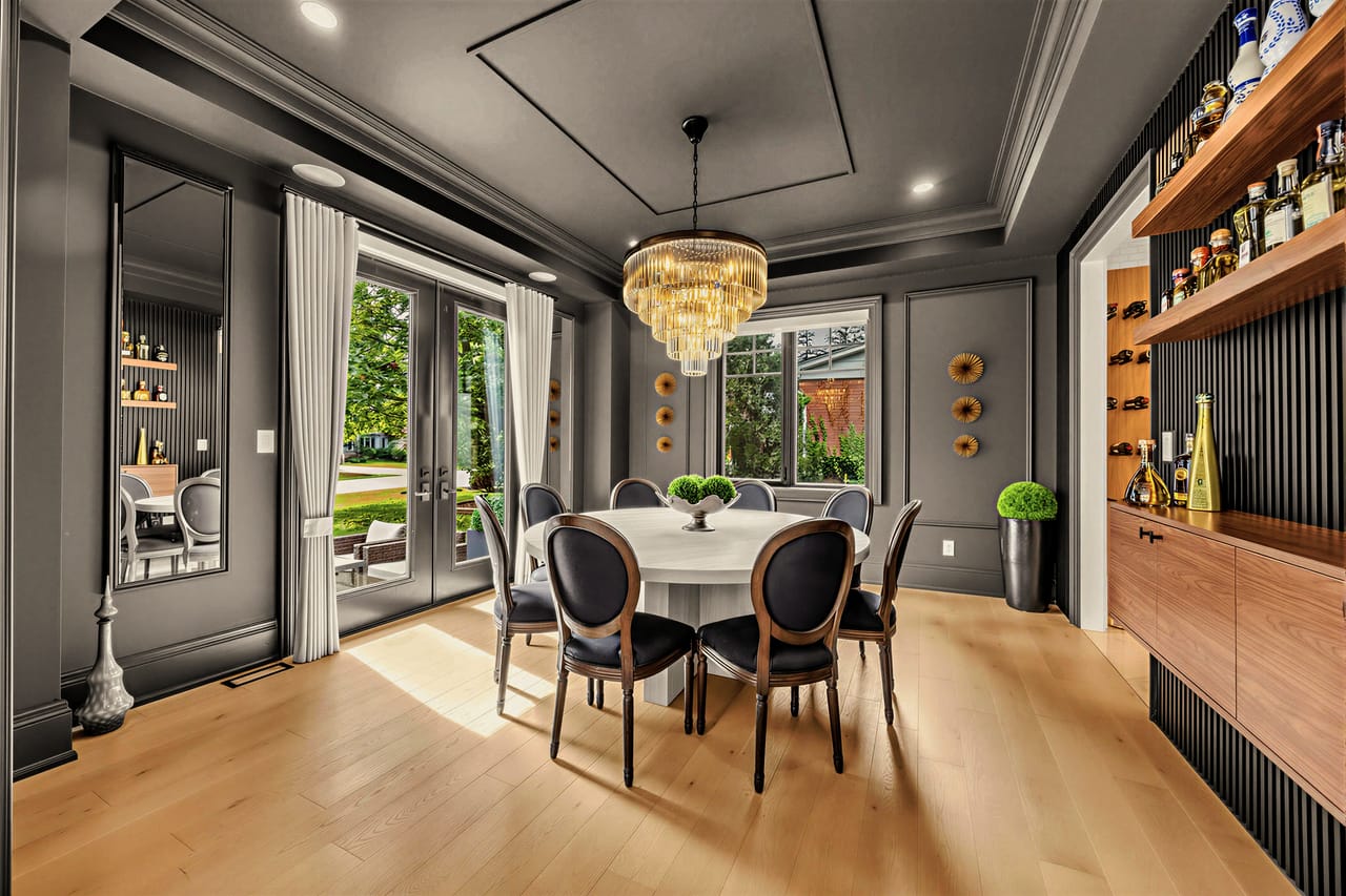 Dining room in charcoal, a faceted brass chandelier above the round table
