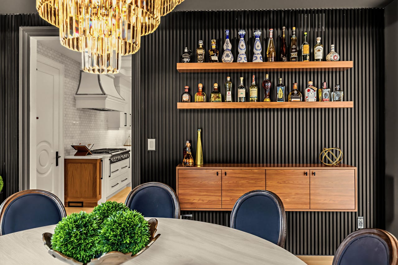 Bar wall in the dining room, oak shelving and cabinetry against vertical charcoal panelling