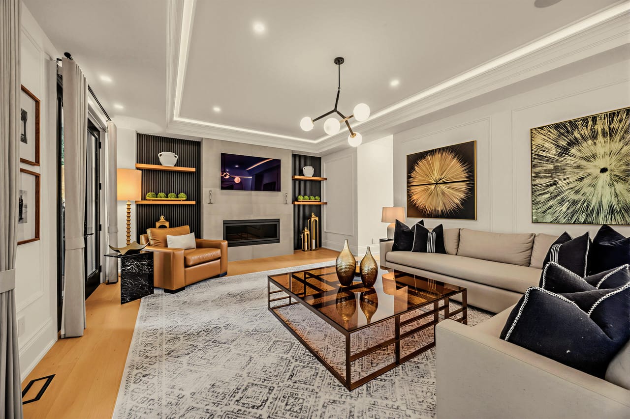 Family room with linear fireplace and built-in shelving beneath a recessed ceiling