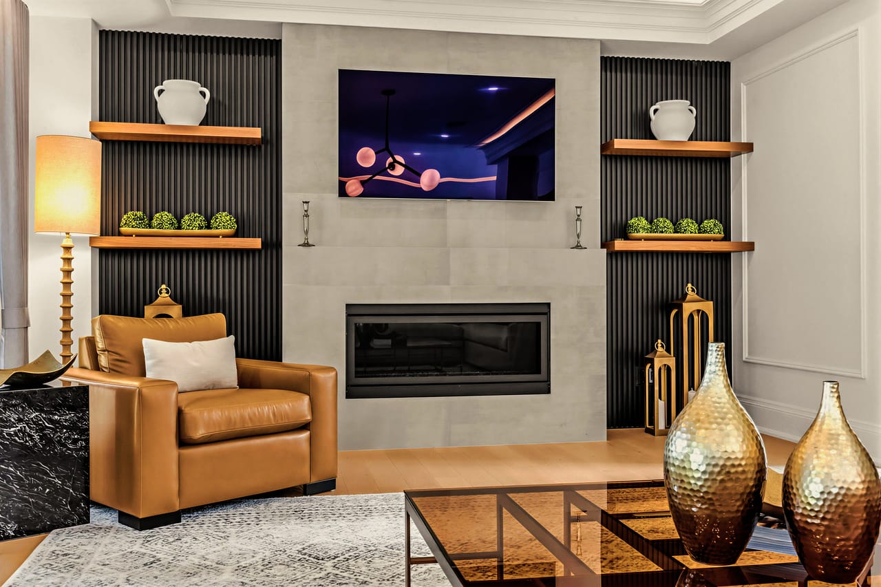 Fireplace surround in honed stone, flanked by oak shelves and fluted panelling