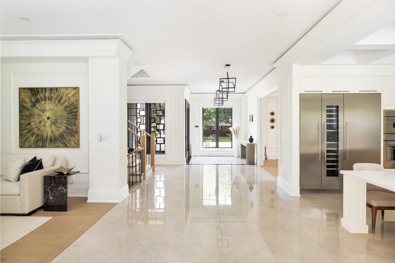 Open main floor flowing from the living area past the foyer to the kitchen, in polished marble