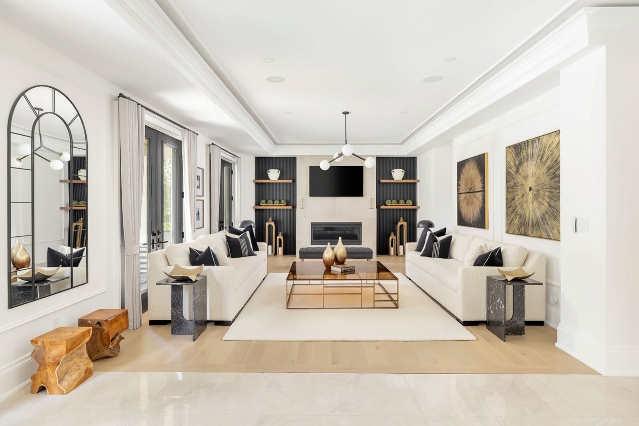 Family room with twin sofas facing a linear fireplace set in fluted built-ins