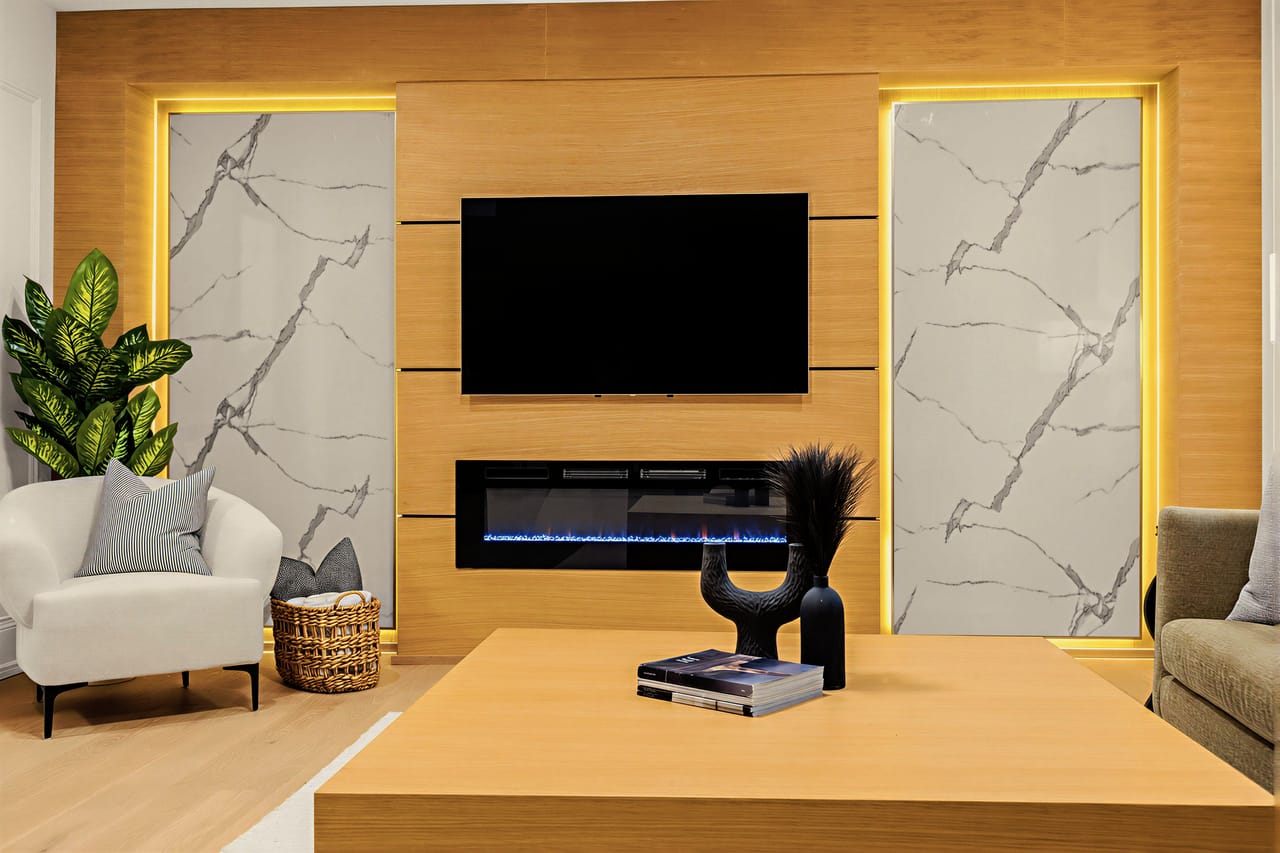 The rec room fireplace on the lower level, a linear burner set between backlit stone panels