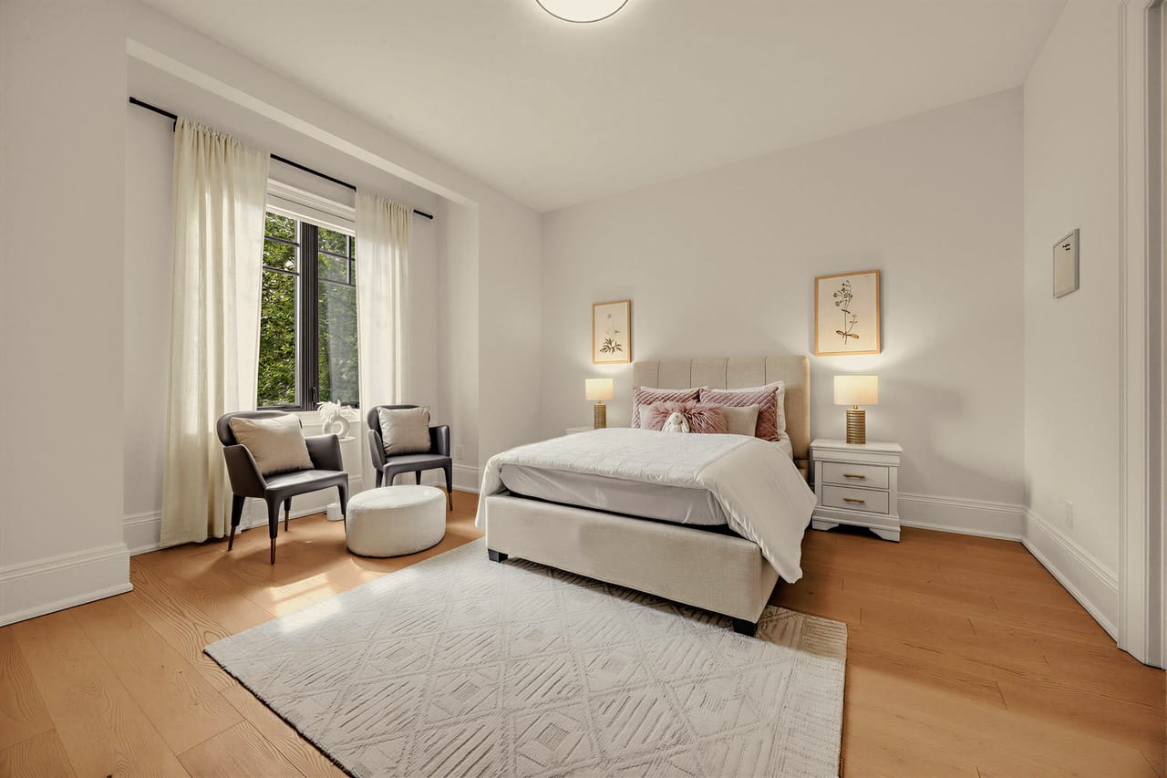 Bedroom with an upholstered bed and a window seating pair, garden view beyond