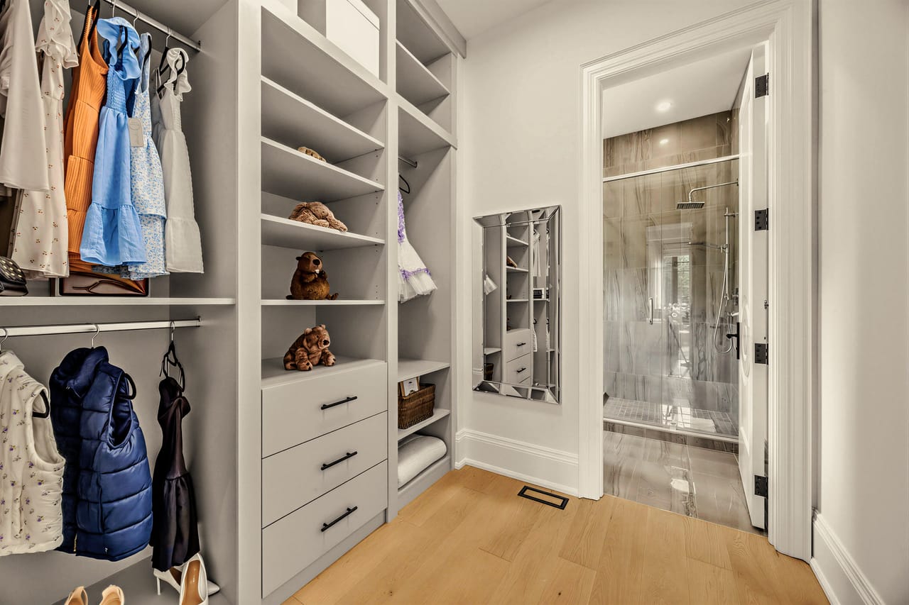 Fitted walk-in closet in white oak, opening through to the ensuite