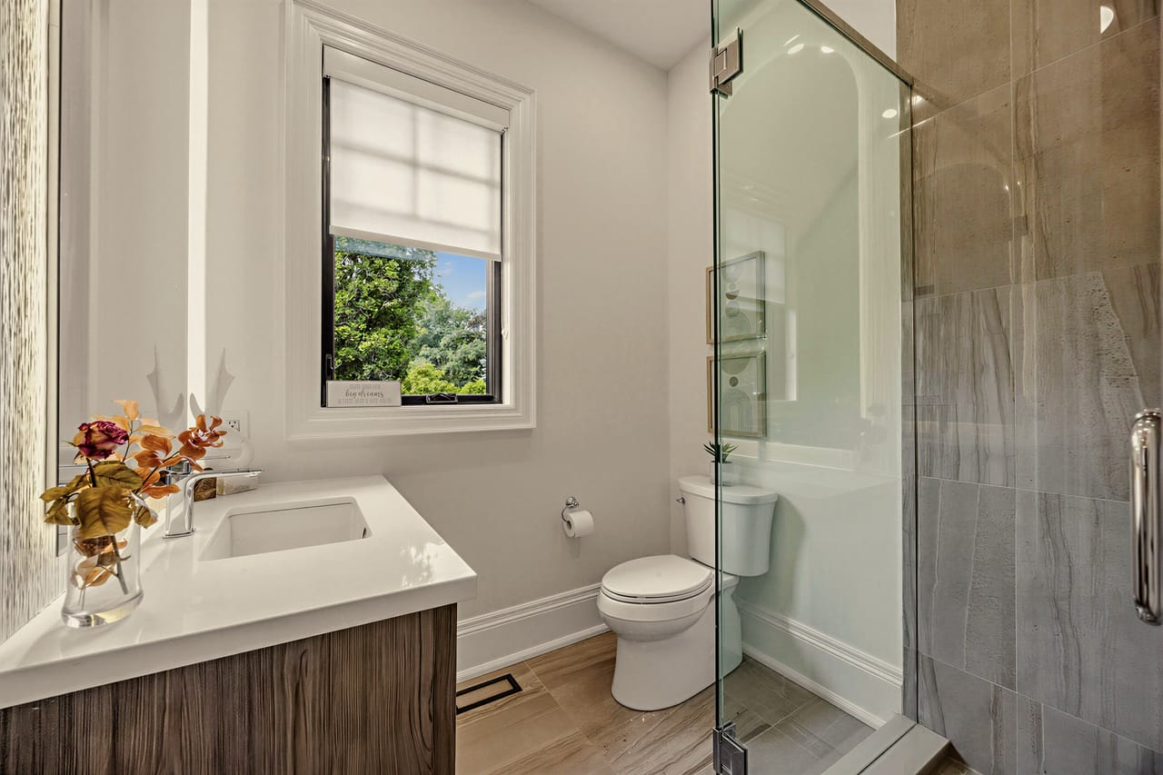 Ensuite bathroom with a glass shower and a window over the vanity