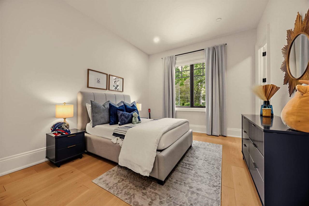 Second bedroom with navy accents and a full window to the treeline