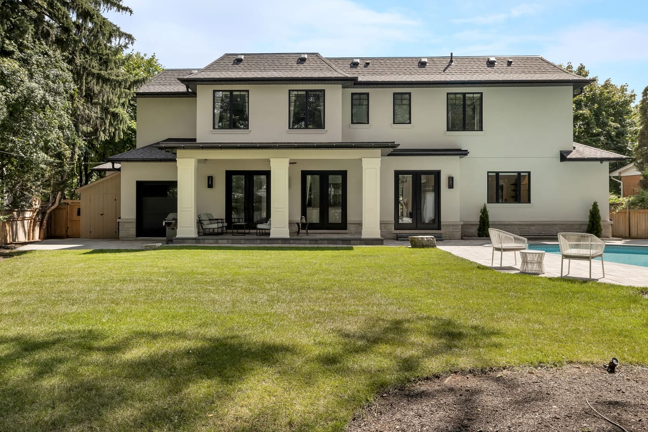 Rear elevation in daylight, the covered loggia and poolside terrace across the lawn