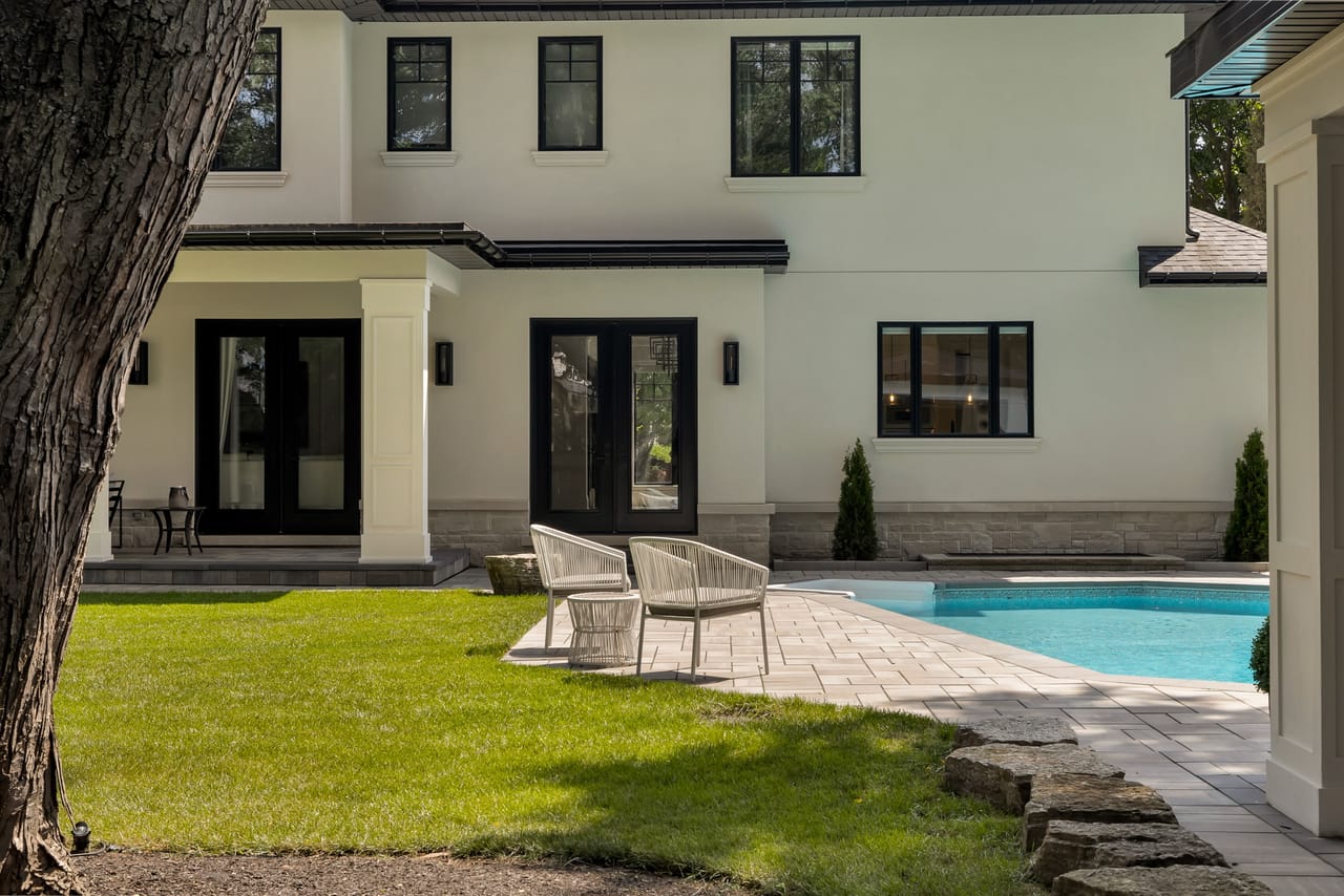 Covered porch with lounge chairs at the edge of the pool