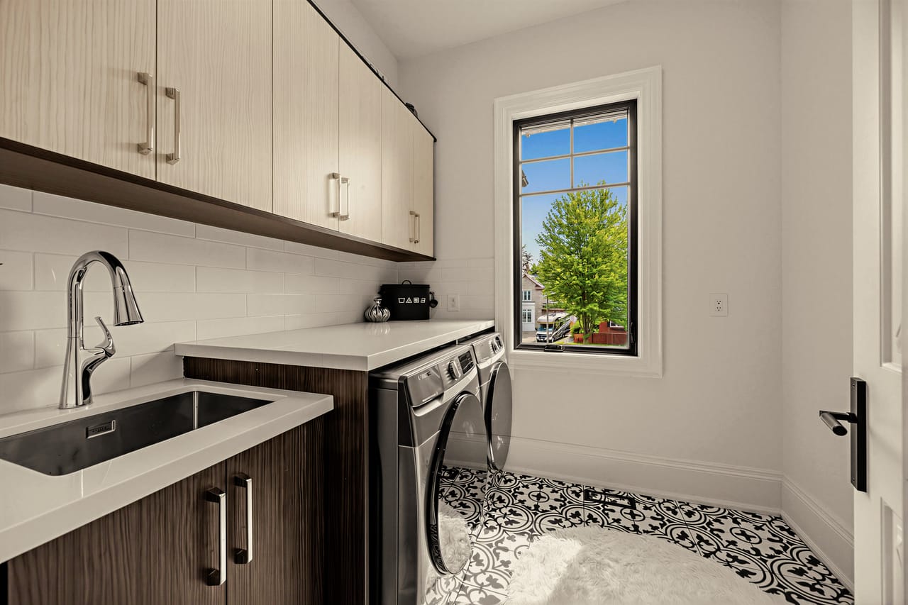 Laundry room with a deep sink, side-by-side machines and full upper cabinetry