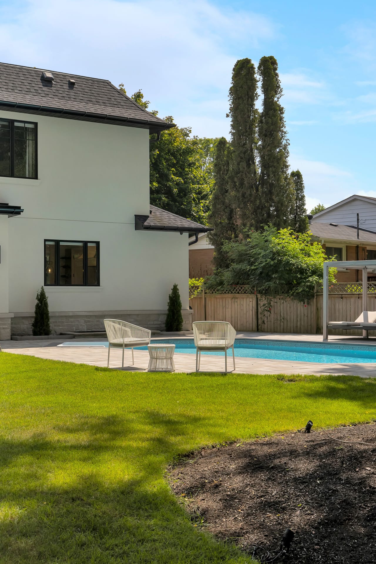 Poolside garden framed by tall columnar cedars