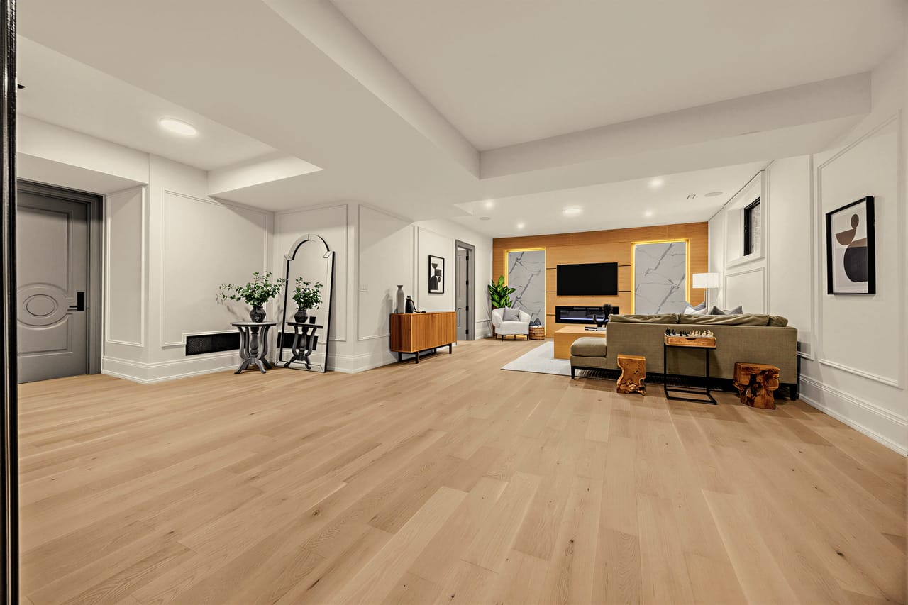 Wide view of the lower level, panelled walls and wide-plank floors throughout
