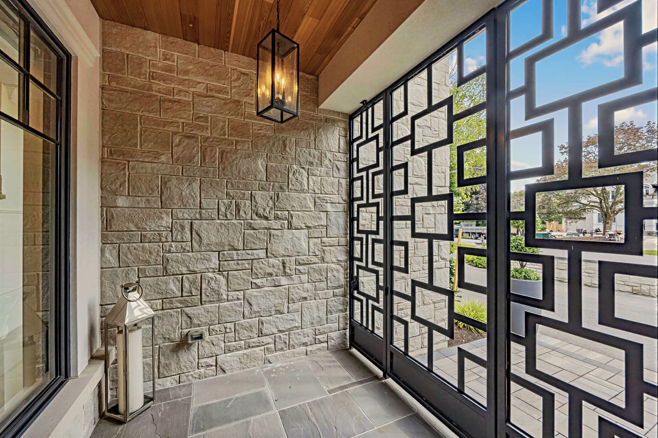 Loggia detail, a laser-cut steel screen filtering light against the stone wall