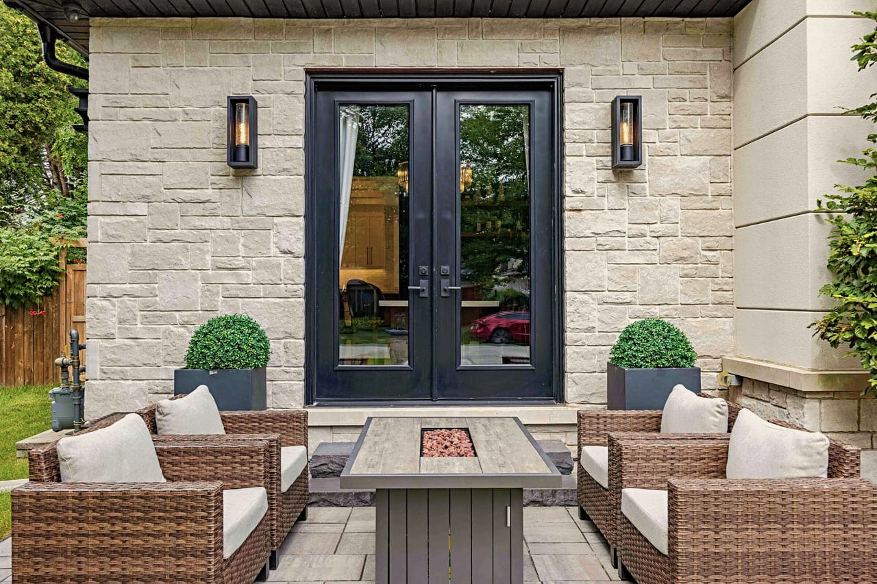 Rear terrace off the garden doors, wicker seating around a gas fire table