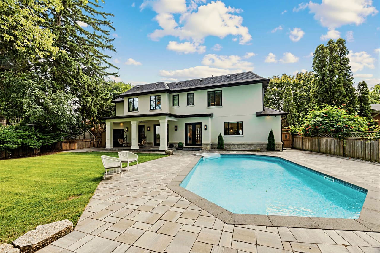 Rear elevation across the lawn, pool terrace running the width of the house