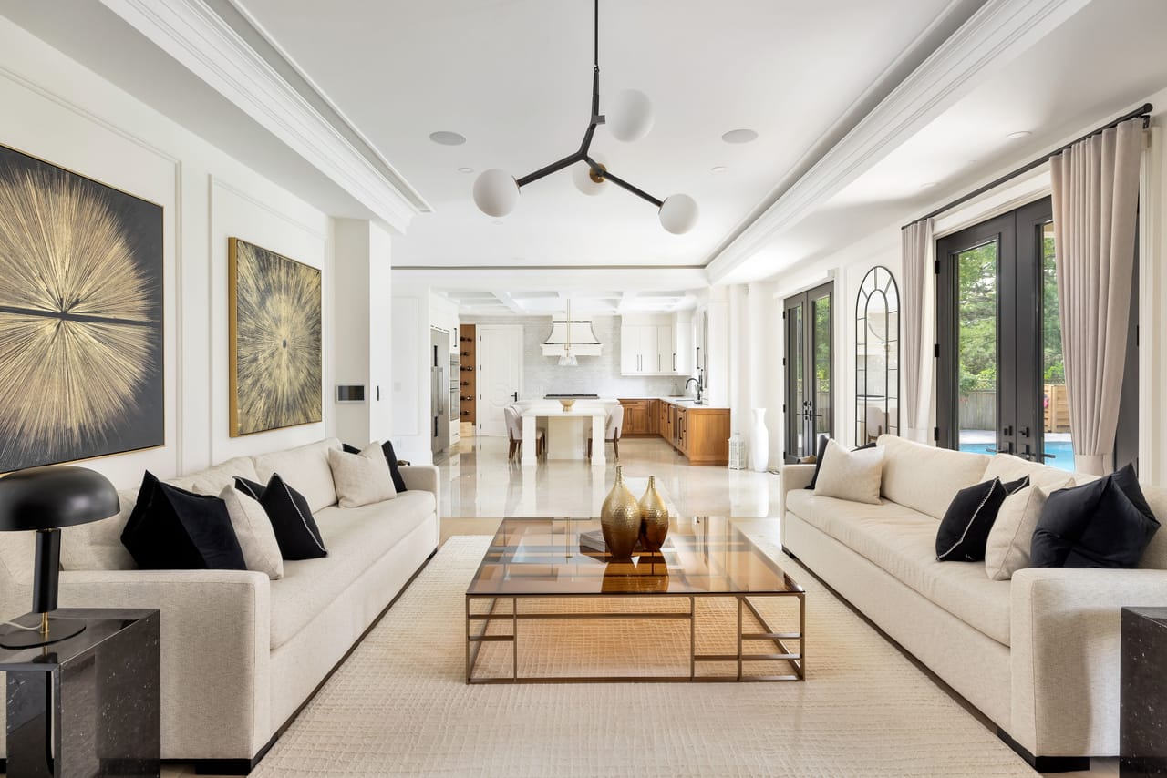 Great room with twin sofas opening to the kitchen and garden doors to the pool