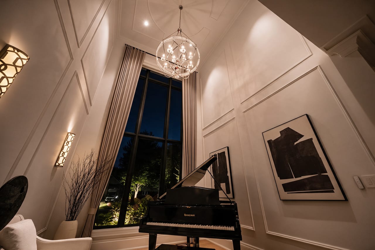 The music room after dark, the two-storey window black behind the grand piano