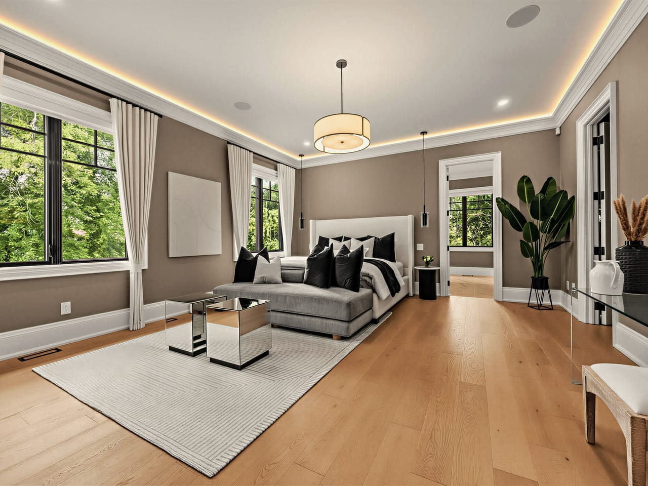 The primary bedroom from the seating end, oak underfoot and treetops on three sides