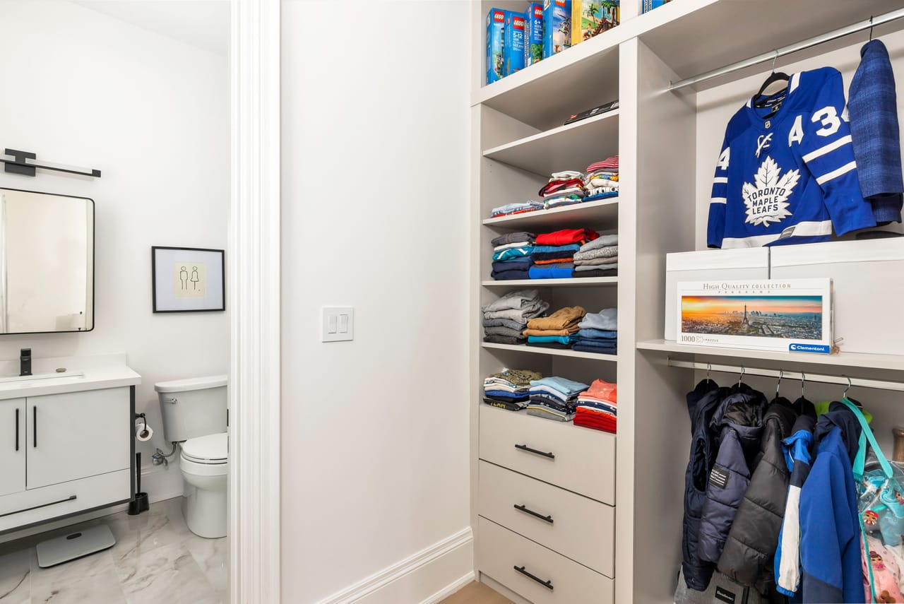 Secondary bedroom's ensuite and fitted closet with open shelving