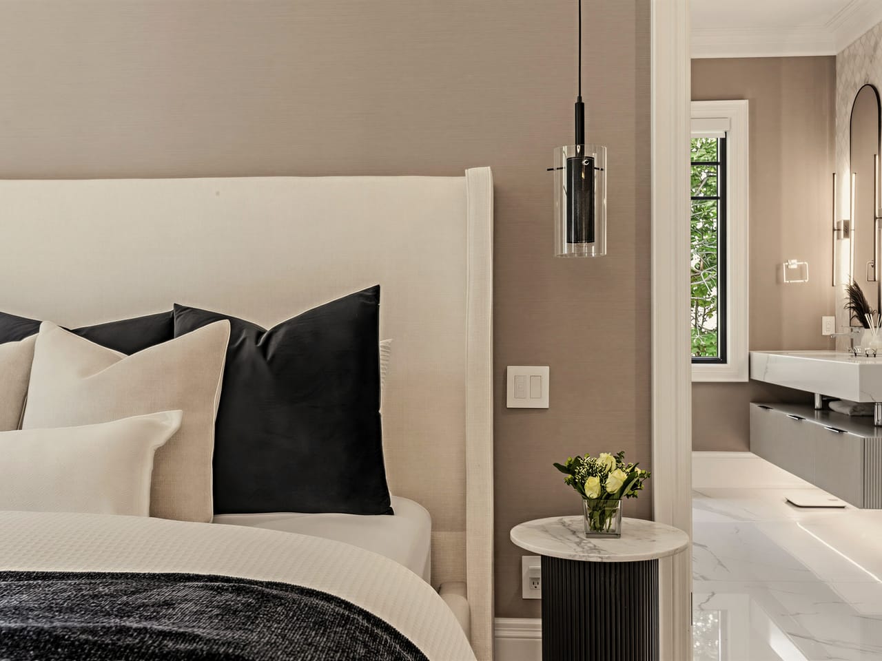 The bed against its upholstered wall, the ensuite open beyond