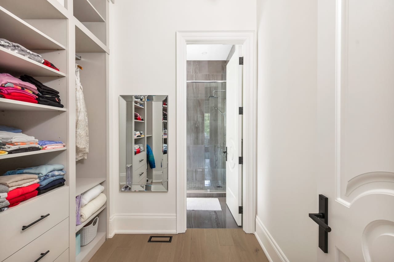 Fitted walk-in closet opening to a private marble ensuite