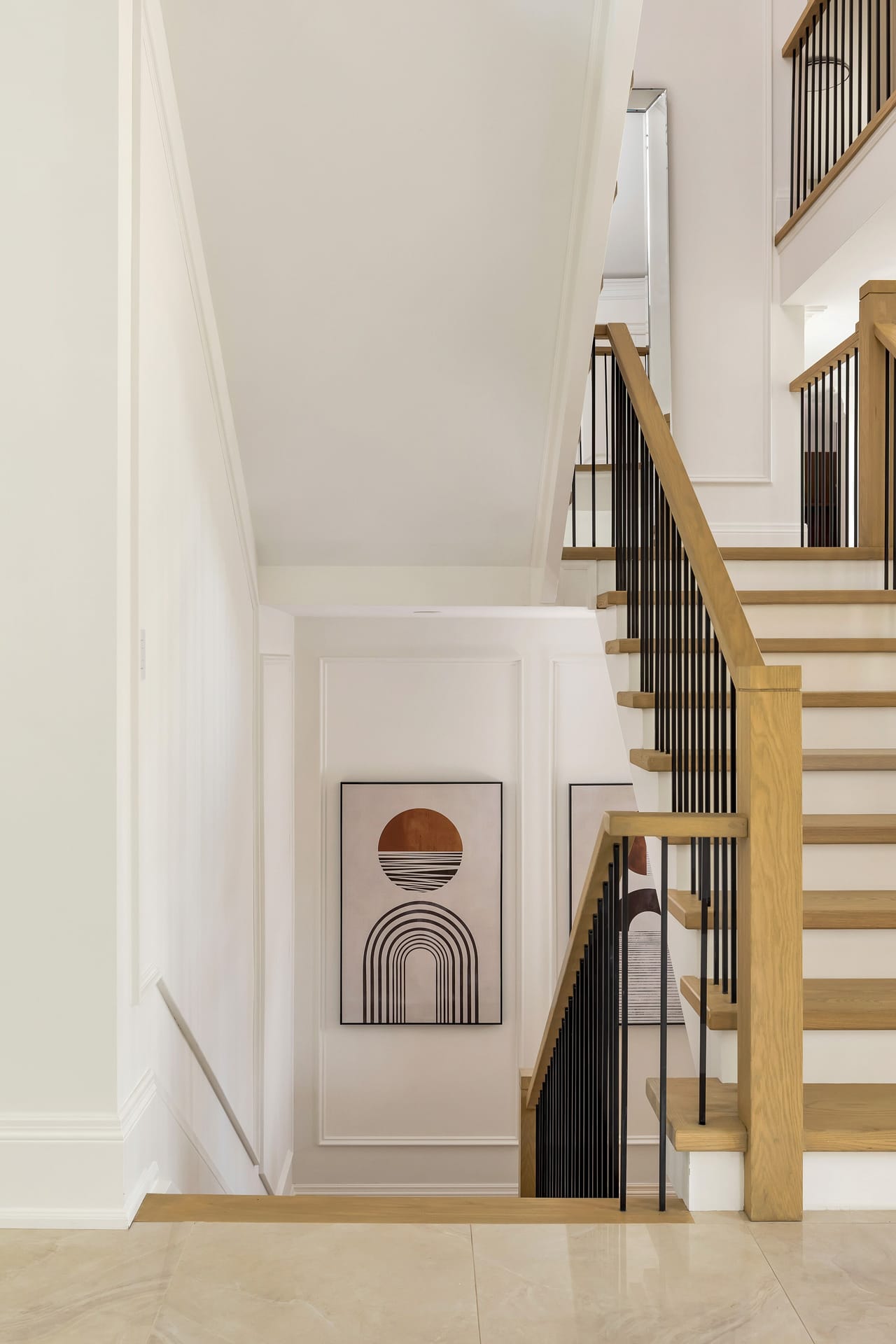 Staircase landing rising through the home past framed artwork