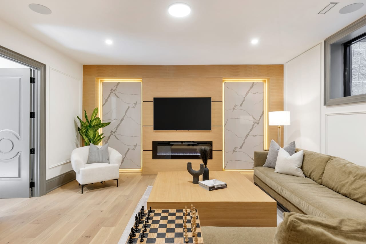 Lower-level lounge seating facing the fireplace and media wall