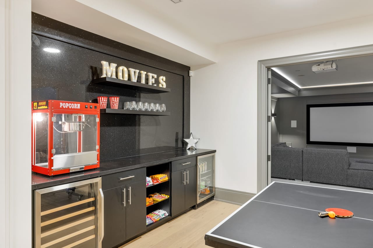 Theatre concession bar with a popcorn cart and beverage fridge beside the screening room